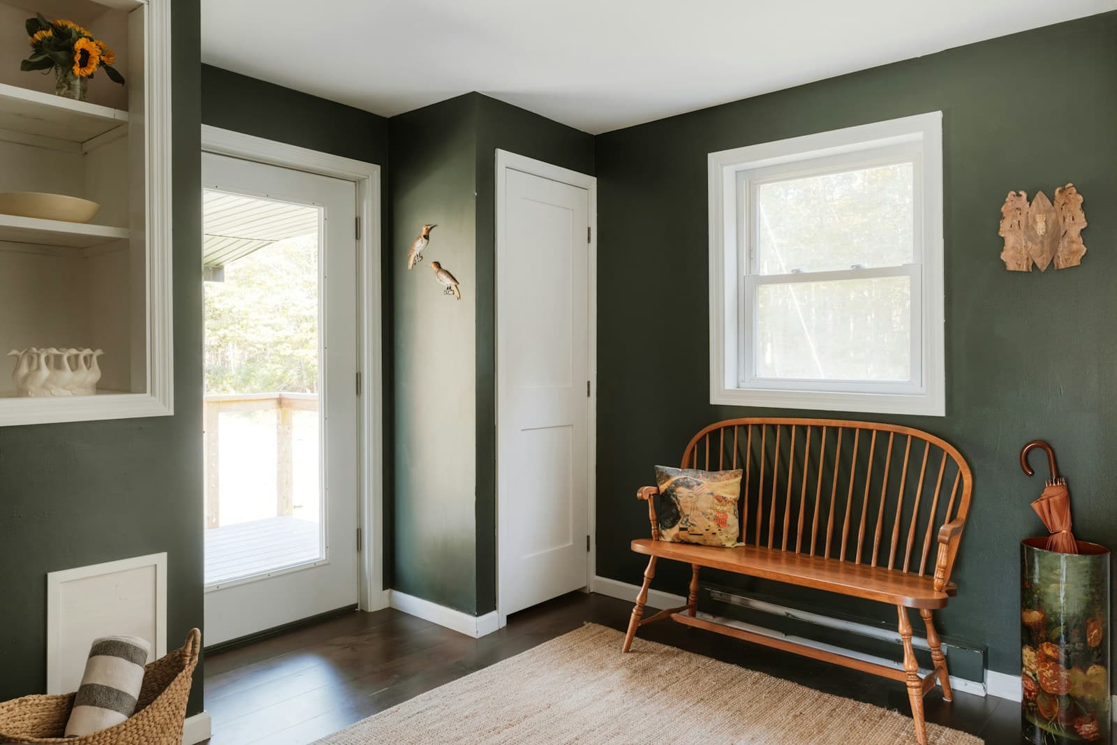 Green entryway with a bench and built-in shelves